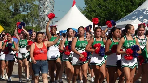 Cheerleaders marching in parade with red and blue pom poms 스톡 동영상 340940865
