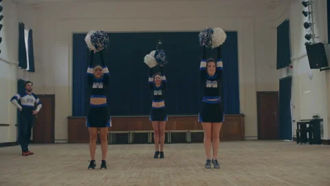 Cheerleaders practicing using pom poms Stock Footage 279751045