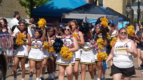 Cheerleading squad marching in parade wearing white uniforms 스톡 동영상 340940992
