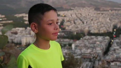 Cheery brunet boy looking at the nice view of Athens on a sunny day in summer 스톡 동영상 118777246