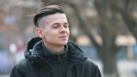 Cheery young student thinking and smiling in an alley outdoors in spring Stock-Footage 107570438