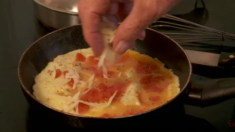 Cheese added to cooking omelette Stock Footage 130797407