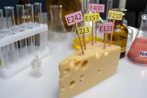 Cheese adorned with additive labels E. Food Laboratory on a lab bench. Stock Photos