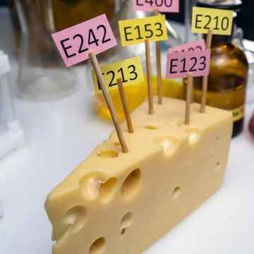 Cheese adorned with additive labels E. Food Laboratory on a lab bench. Stock Photos