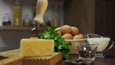 Cheese and eggs are on the kitchen table, ingredients for cooking omelette at Stock Footage 93878489