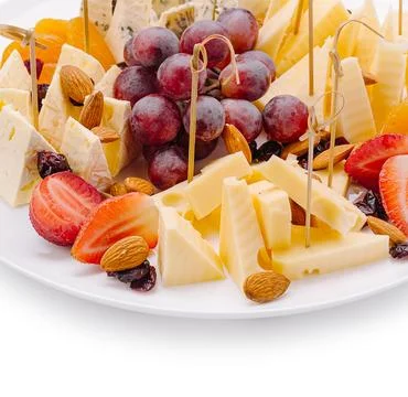 Cheese and fruit platter with nuts and dried fruits arranged for a snack Stock Photos