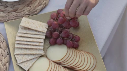 Cheese and fruit platter on table with man serving food Stock Footage 270248503