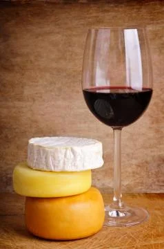 Cheese and glass of red wine Stock Photos