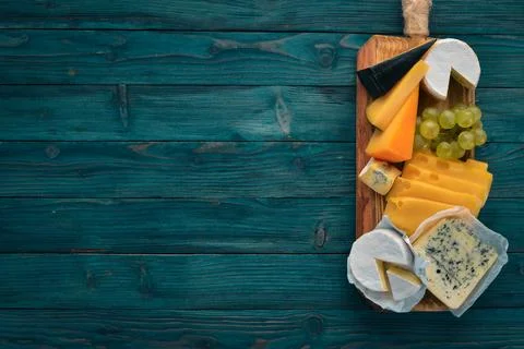 Cheese and snacks. Top view. On a blue wooden background. Free space for yo.. Stock Photos