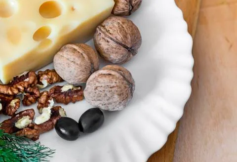 Cheese and walnuts on a plate. Stock Photos