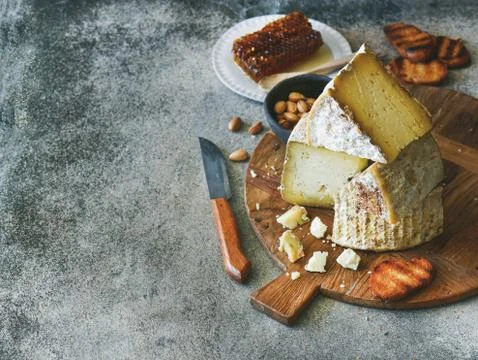 Cheese assortment and snacks on rustic wooden board, copy space Stock Photos