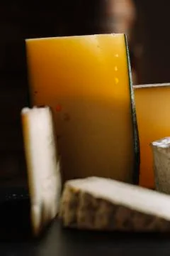 Cheese assortment on black background. Various sorts of cheese for appetizing Stock Photos