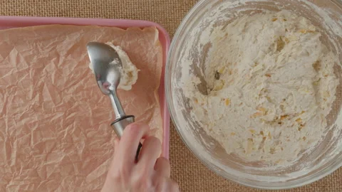 Cheese biscuits recipe, baking process. Woman scooping biscuit daugh into a baki Stock Footage 230530036