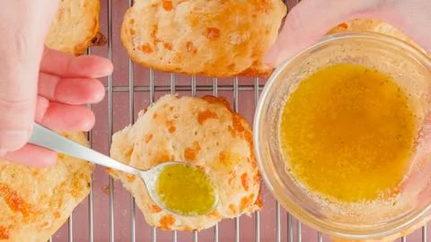 Cheese biscuits recipe, baking process. Woman topping freshly baked biscuit.. Stock-Fotos