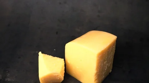 Cheese on a black background. pieces of cheese on a black background. Stock Footage 99587144