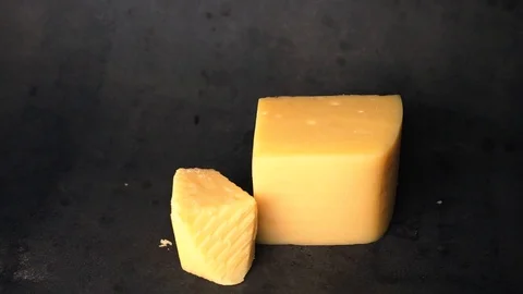 Cheese on a black background. pieces of cheese on a black background. Stock Footage 99587157