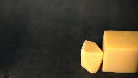 Cheese on a black background. pieces of cheese on a black background. Stock Footage 99587159