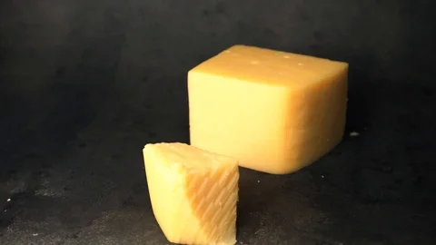 Cheese on a black background. pieces of cheese on a black background. Stock Footage 99587160
