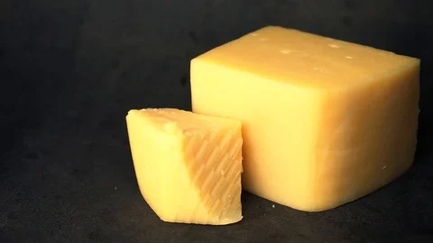 Cheese on a black background. pieces of cheese on a black background. Stock Footage 99587162