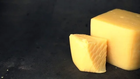 Cheese on a black background. pieces of cheese on a black background. Stock Footage 99587173