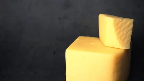 Cheese on a black background. pieces of cheese on a black background. Stock Footage 99587174