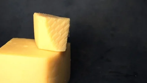 Cheese on a black background. pieces of cheese on a black background. Stock Footage 99587181