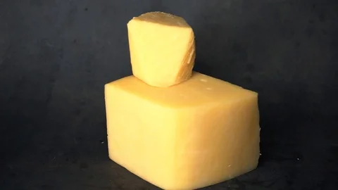 Cheese on a black background. pieces of cheese on a black background. Stock Footage 99587185