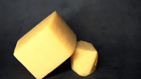 Cheese on a black background. pieces of cheese on a black background. Stock Footage 99587191