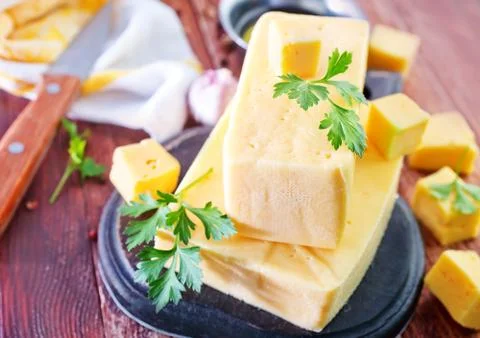 Cheese on board and on a table Stock Photos