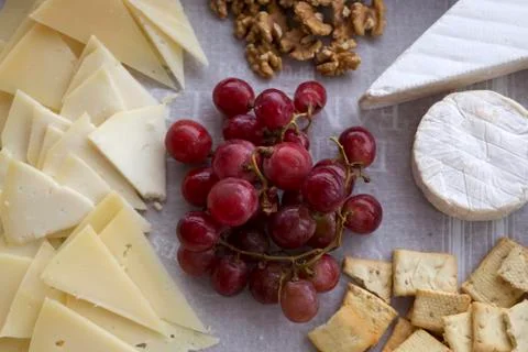 Cheese board with different types of sliced and soft cheese, grapes, bread Stock Photos