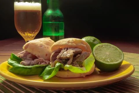 Cheese bread stuffed with pork, onion, lettuce and lemon with beer drink. Foto stock