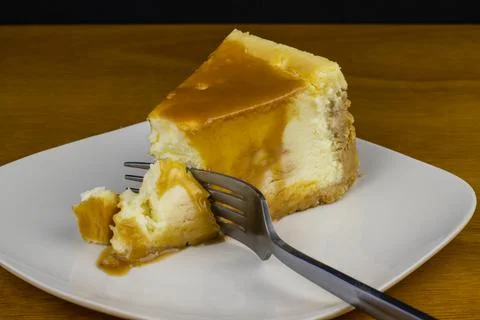 Cheese cake top with carmeland a fork on top Stock Photos