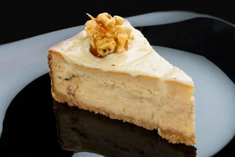 Cheese cake with walnuts on a dark background Stock Photos