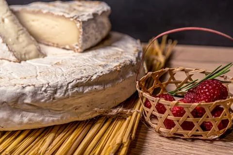 Cheese Camambert with raspberry basket. Rustic set on black backdrop. Healthy Stock-Fotos