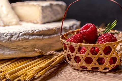 Cheese Camambert with raspberry basket. Rustic set on black backdrop. Healthy Stock Photos