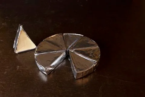 Cheese in creamy triangular spreads, wrapped in aluminum foil Stock Photos