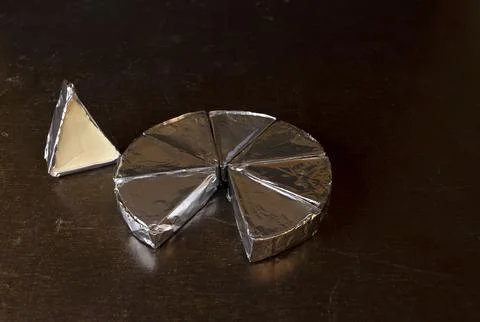 Cheese in creamy triangular spreads, wrapped in aluminum foil Stock Photos