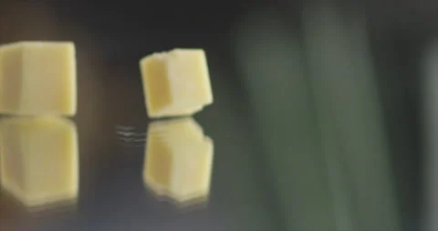 Cheese cubes fall to mirror surface in slow motion Stock Footage 198560561
