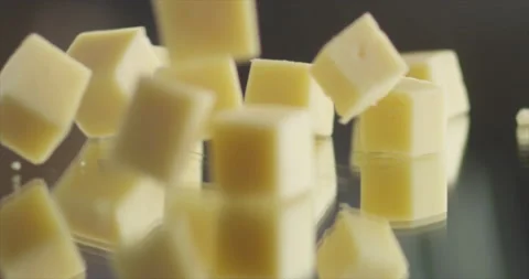 Cheese cubes fall to mirror surface Stock Footage 199022474