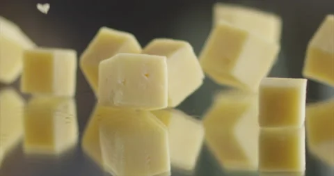 Cheese cubes fall from side to mirror surface Stock Footage 198146931