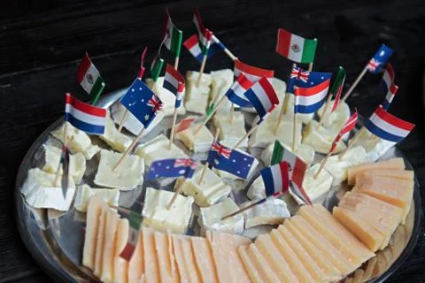Cheese cubes with flags. Yellow Edam cheese blocks Stock Photos