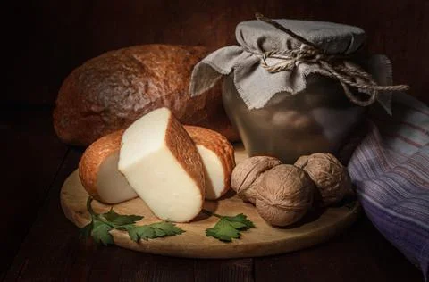 Cheese on a cutting board in a rustic style on a dark wooden background Stock Photos