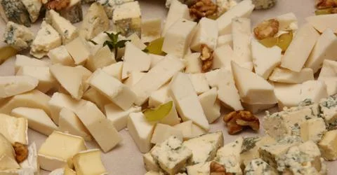 Cheese cutting with nuts and mint close-up. Stock Photos
