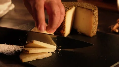 Cheese cutting process with herbs on a dark board. Stock Footage 169995760