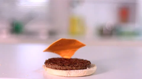 Cheese falling on bun burger in kitchen Stock Footage