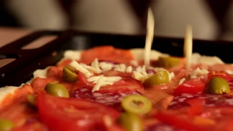 Cheese falling down on homemade pizza with peperoni olves and tomatoes Stock Footage 157055685
