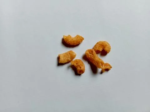 Cheese-flavored crispy macaroni snack, on a white background. Фото