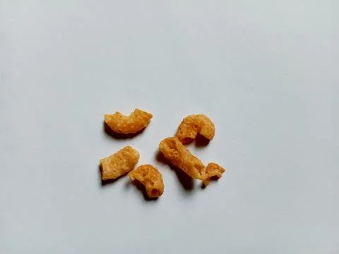 Cheese-flavored crispy macaroni snack, on a white background. Фото
