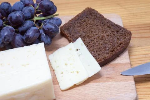 Cheese, grapes and bread Stock-Fotos