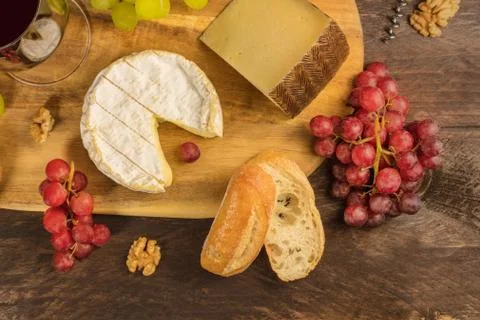Cheese, grapes, and corkscrew on rustic texture with copyspace Stock Photos
